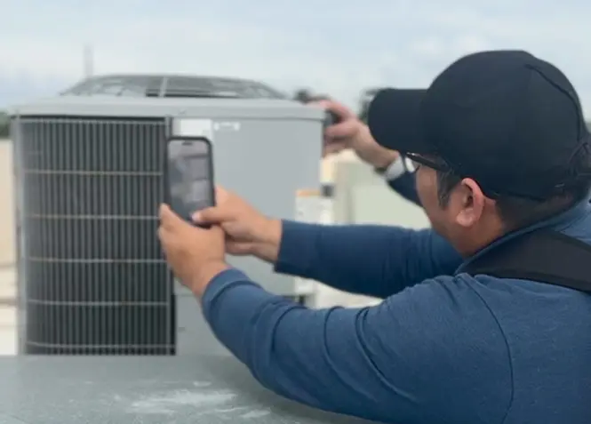 Technician tagging asset on the rooftop of a grocery store